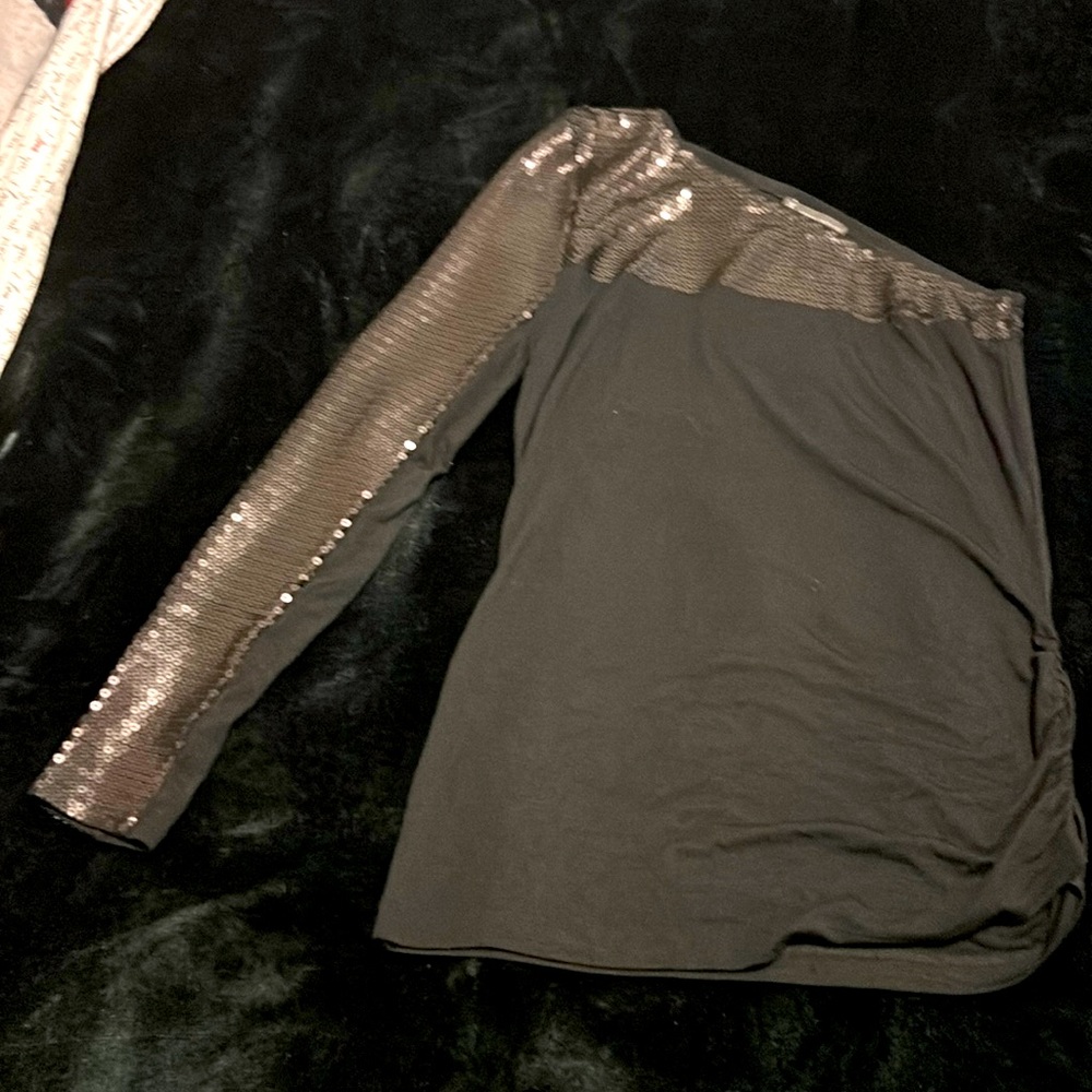 a black blouse with a single shiny sleeve,